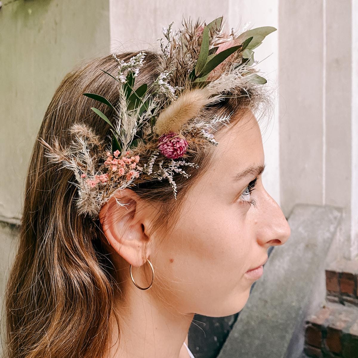Frau trägt Eukalyptus-Blumenkrone mit rosa Blüten – diy blumenkrone, flower crown, blumenkranz workshop