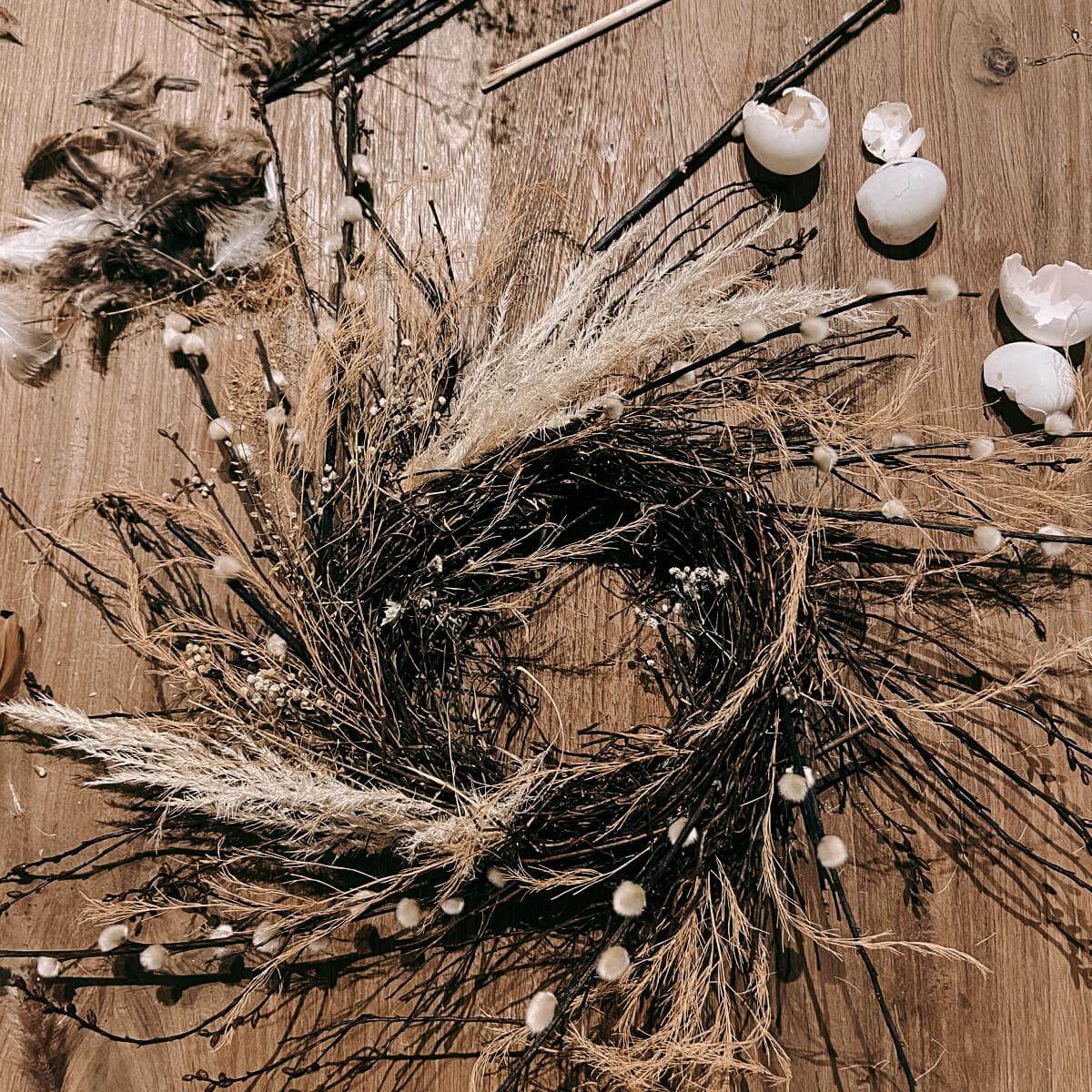 Angefangener Osterkranz mit vielen Zweigen auf Tisch – Osterkranz Workshop Teamevent oder JGA.