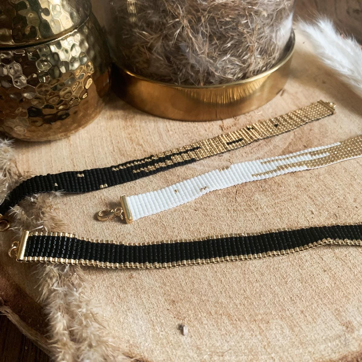 Drei Boho-Perlenarmbänder in verschiedenen Farben auf Tisch – stilvolles Accessoire für Damen.