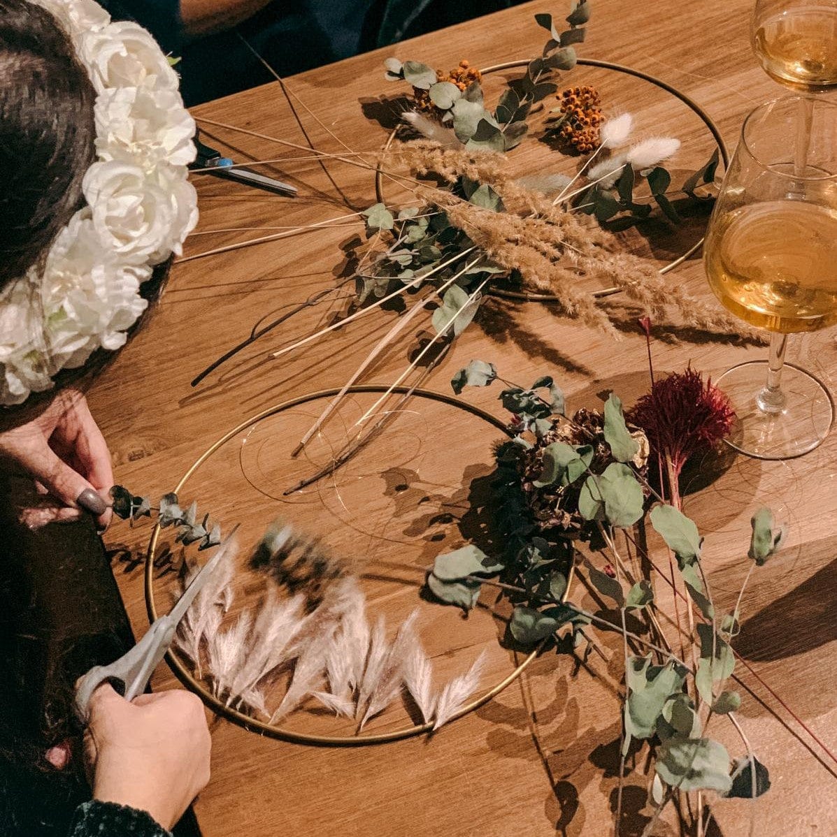 Person schneidet Blume und arbeitet am Trockenblumenring – Boho DIY Workshop, Junggesellinnenabschied.