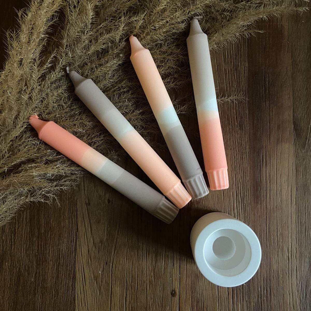 Handgetauchte Dip Dye Kerze „Len“ im Kerzenständer mit weiteren Kerzen daneben – natürliche Eleganz.