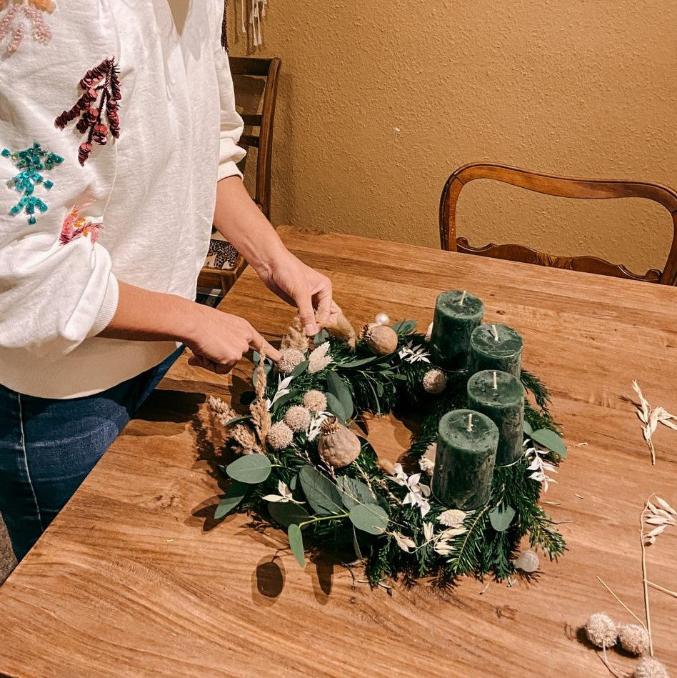 Person steckt Trockenblumen in Adventskranz – kreative Weihnachtsdeko DIY Box Hänsel.