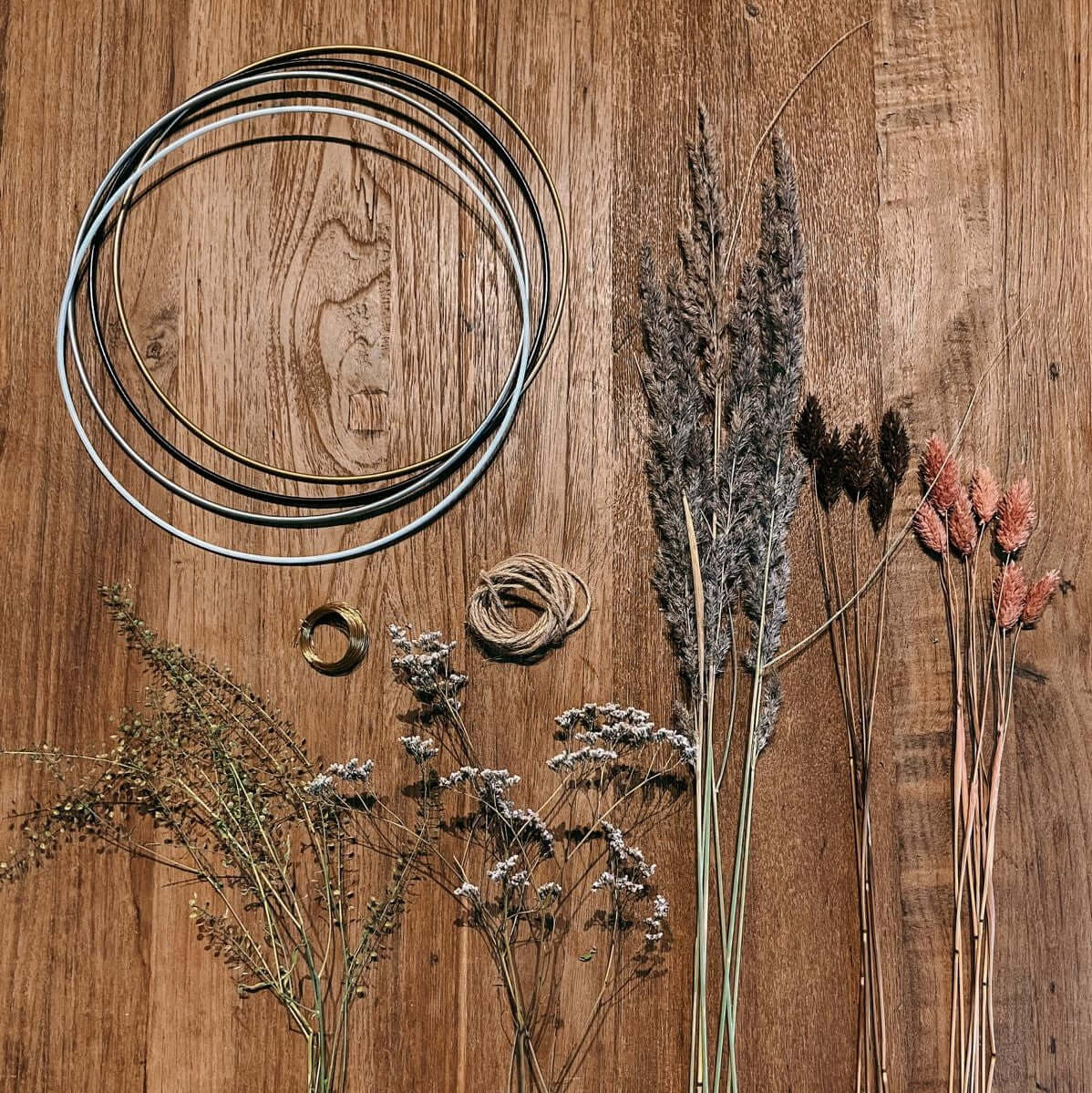 Verschiedene Trockenblumenringe mit Blütenmix auf Tisch – kreative DIY Wanddeko Ideen.