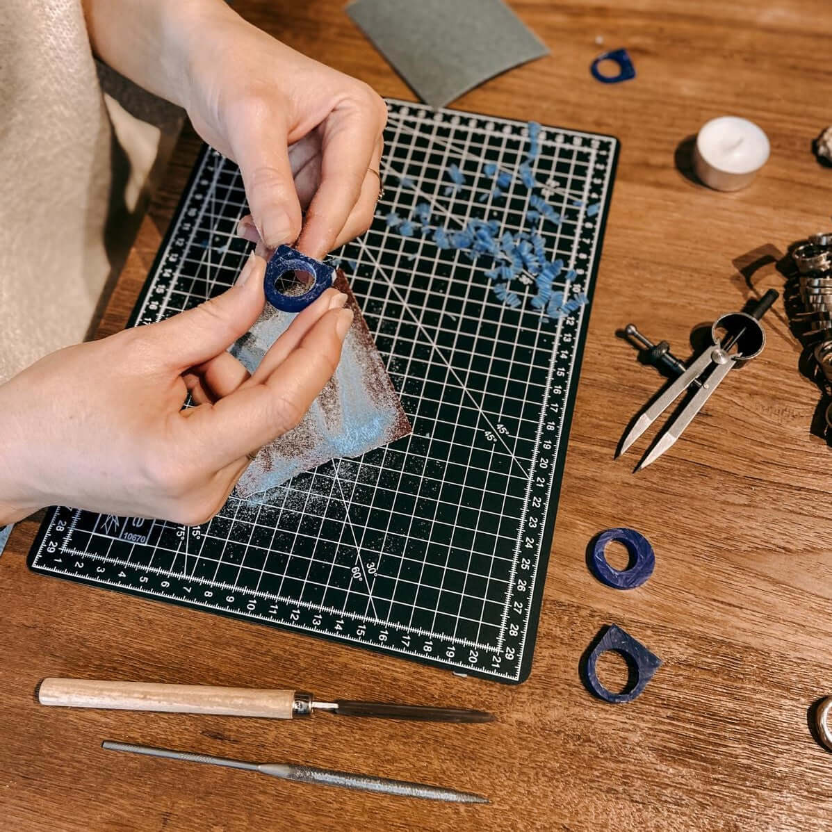 Person arbeitet an Ring, Material im Hintergrund – DIY Ring Workshop, individuelles Schmuckstück, Goldschmiedekurs.