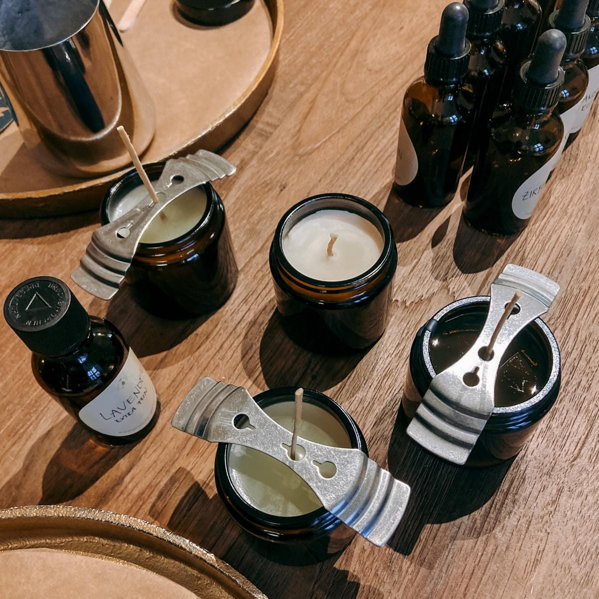 Fertige vegane Duftkerzen trocknen auf Tisch mit Duftfläschchen – DIY Kerzen Workshop, Team-Event buchbar.