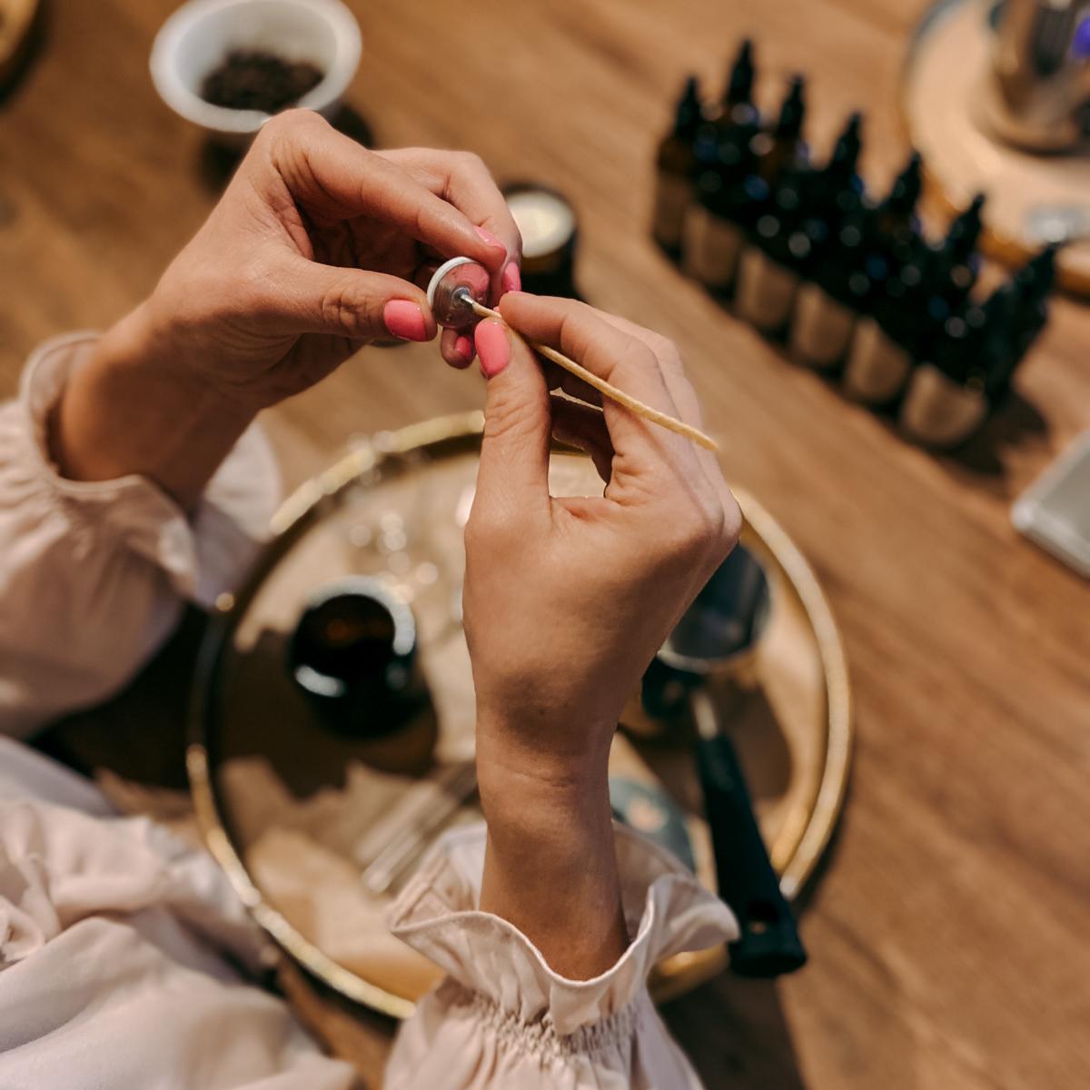 Zwei Hände halten Kerzendocht – vegane Duftkerzen Workshop, perfekt als Firmenevent.