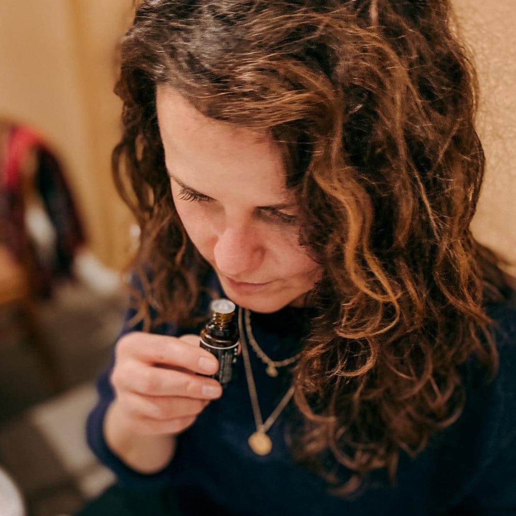 Frau riecht an ätherischem Öl – Badekugel, Aromatherapie, DIY Workshop.