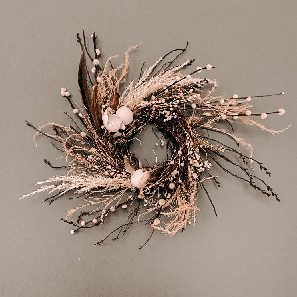 Fertiger Osterkranz mit vielen Elementen an Wand hängend – Workshop als JGA oder Teamevent buchbar.