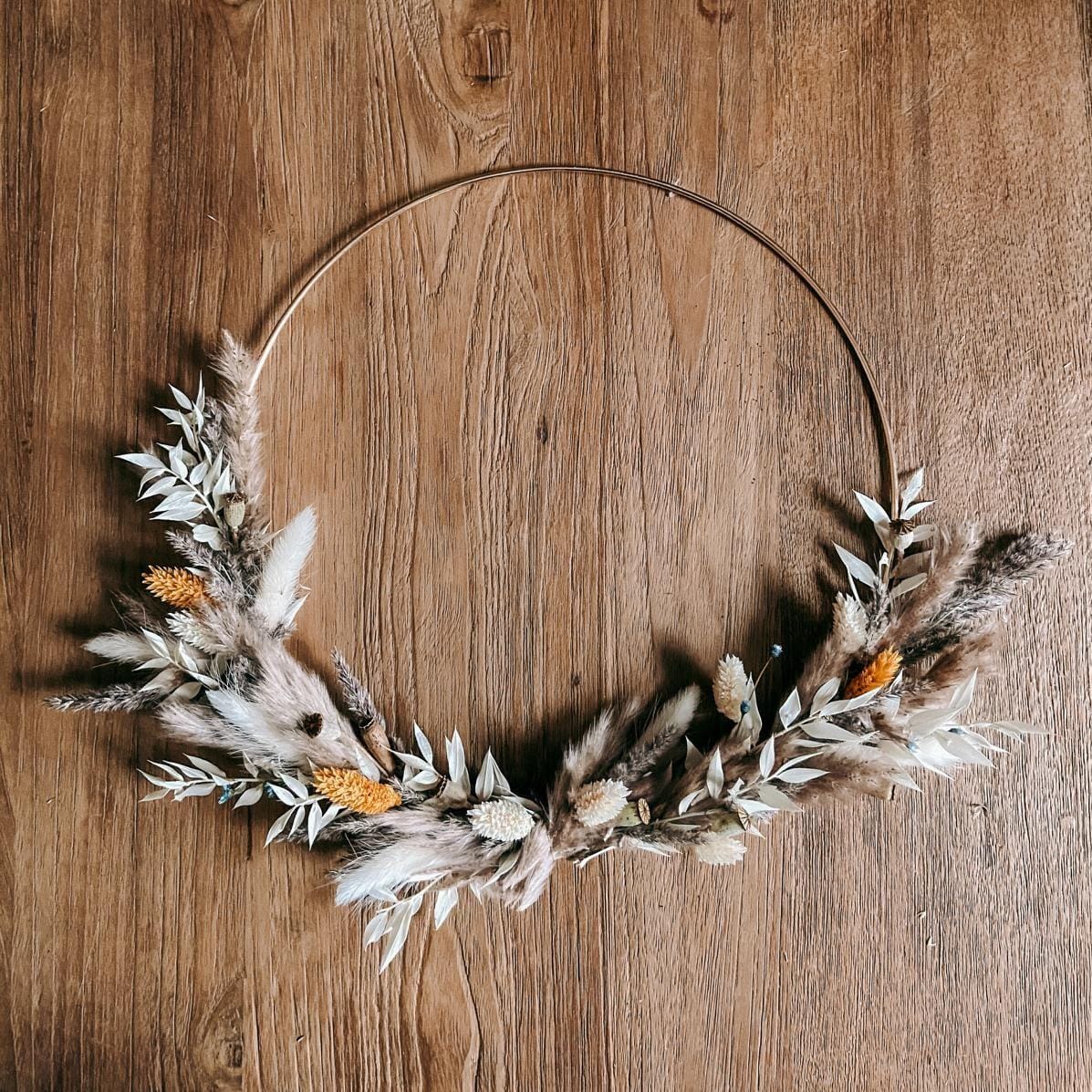 Fertiger Ring mit weiß-orangen Blumen auf Holztisch – Trockenblumen Workshop, Junggesellinnenabschied.