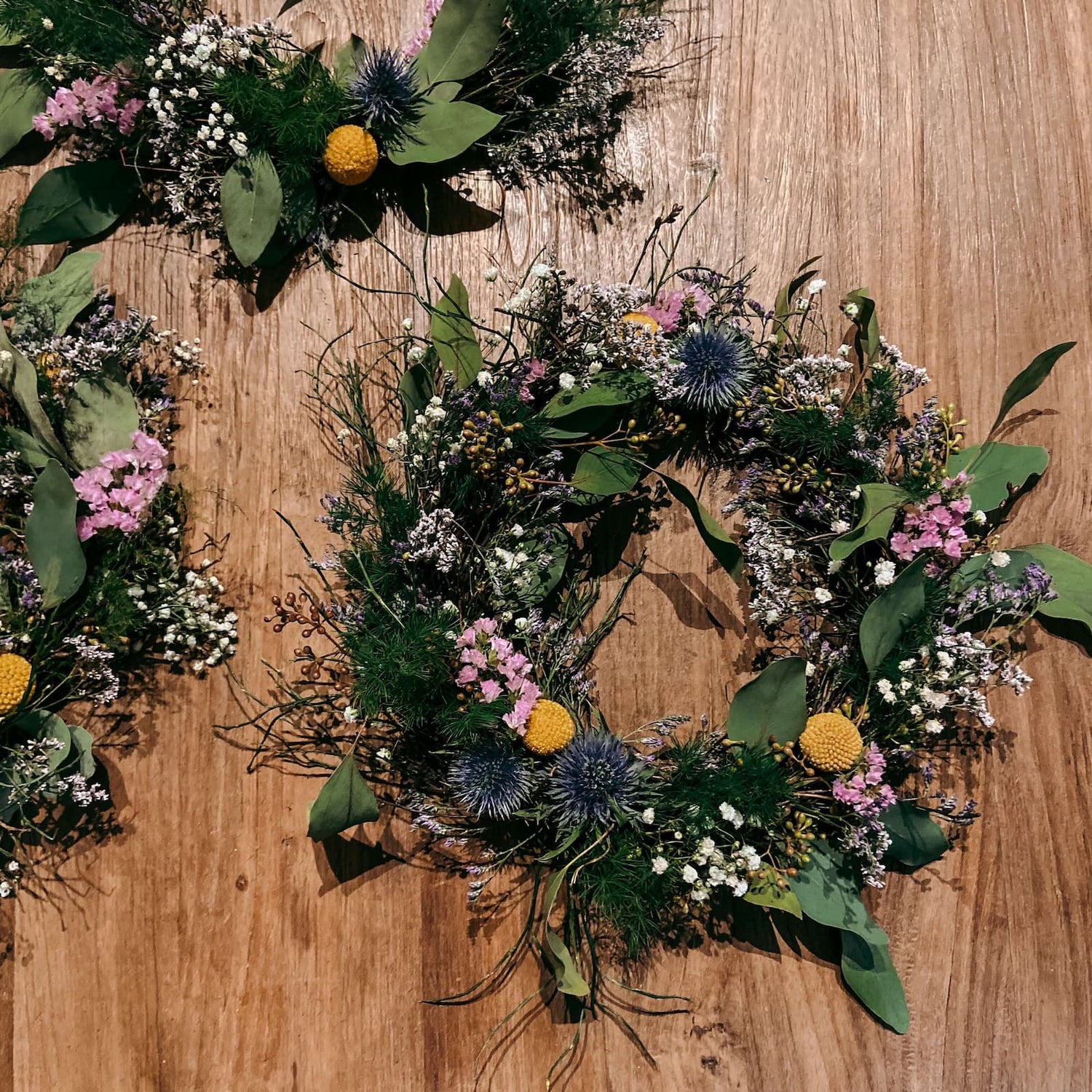 Bunter Frühlingskranz auf Tisch mit weiteren Kränzen im Hintergrund – Teamevent und JGA.
