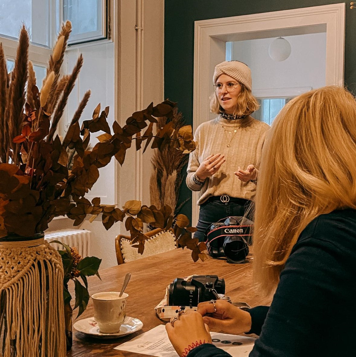 Person erklärt anderer Person Kamera – Fotokurs für Anfänger, Kamera optimal einstellen und fotografieren lernen.