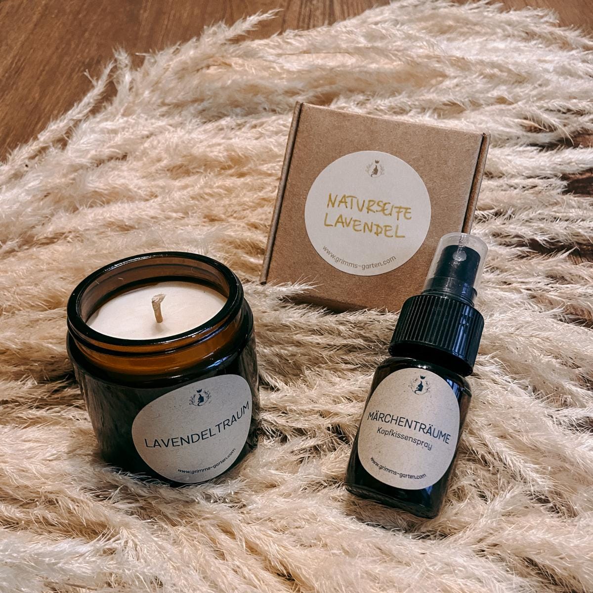 Geschenkset Lavendel mit veganer Duftkerze „Lavendeltraum“, Kopfkissenspray „Märchenzauber“ und Lavendelseife, stilvoll verpackt auf Tisch.