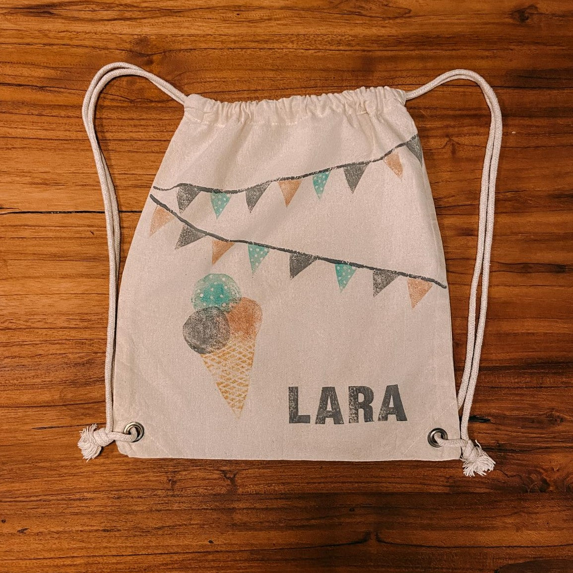 Jutebeutel mit Namen „Lara“ und Stempeldesign auf Tisch – stoff bedrucken, diy textil workshop, handmade design, auch für Firmenevents.