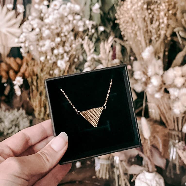 Hand hält Schmuckbox mit Perlenschmuck Kette Dreieck in Gold, hochwertiger Boho-Schmuck aus japanischen Perlen.