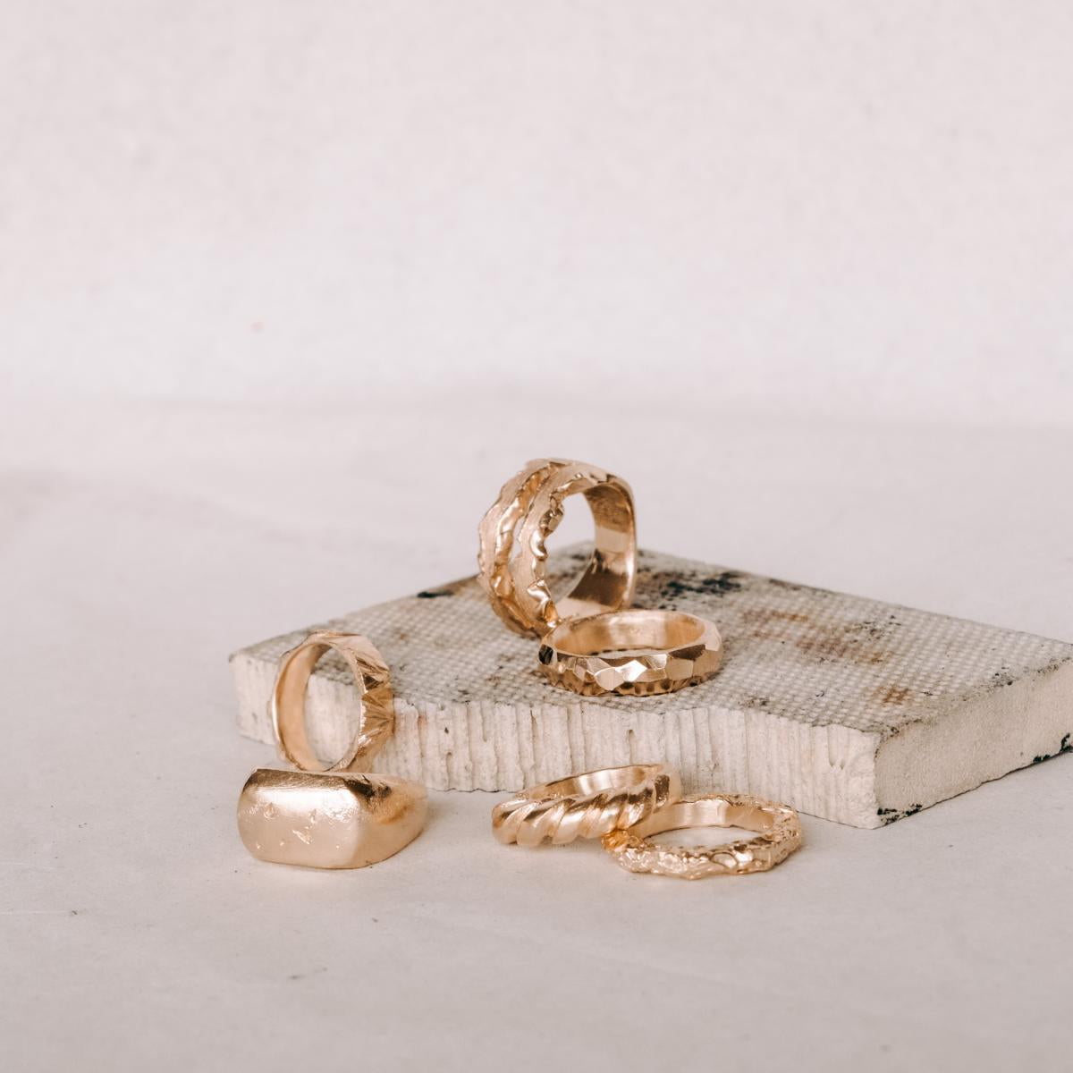 Verschiedene goldene Ringe auf Präsentationsplattform – DIY Ring Workshop, individuelle Ringe, Goldschmiede.