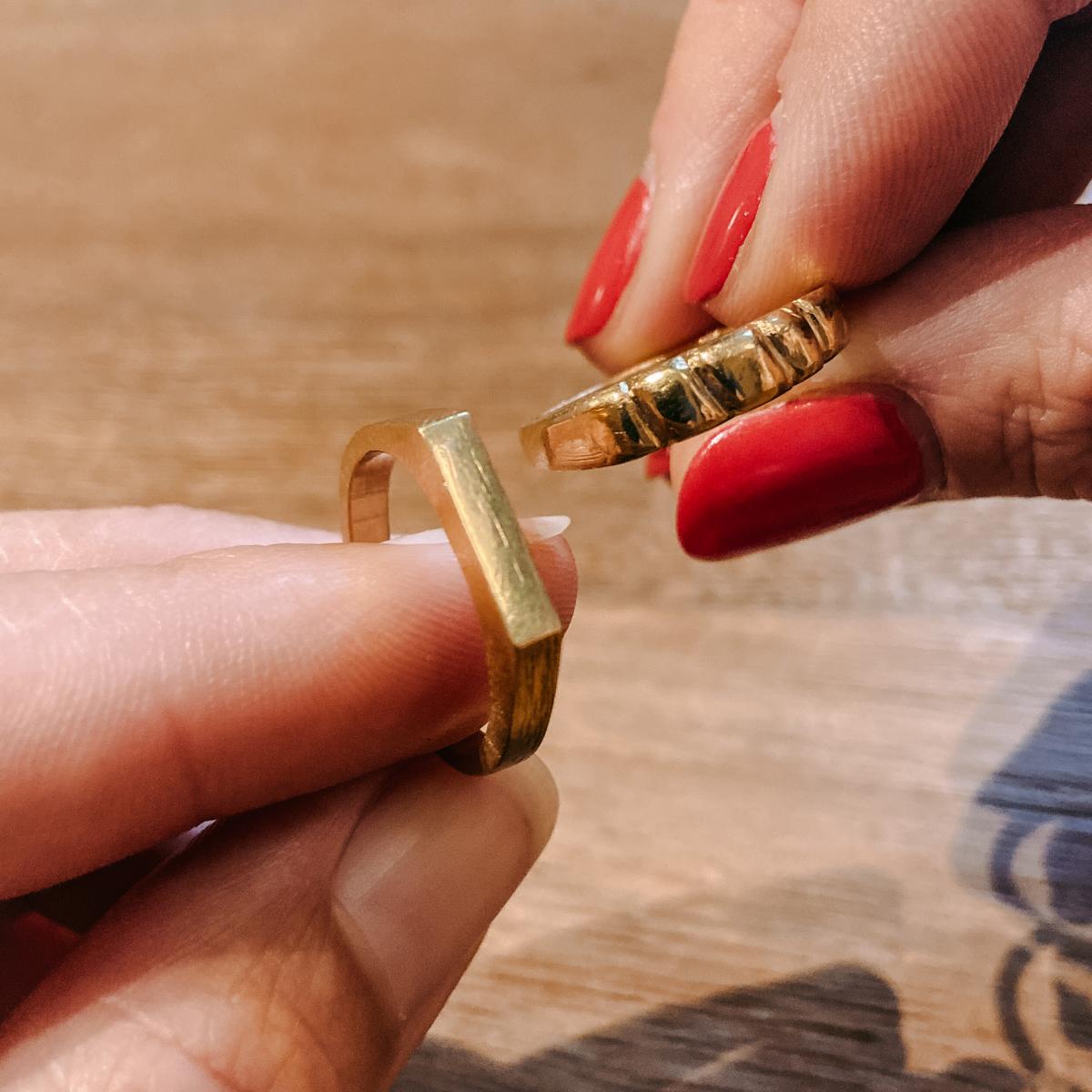 Zwei Hände zeigen fertige goldene Ringe – DIY Ring Workshop, Ring selbst gestalten, individuelles Schmuckstück.