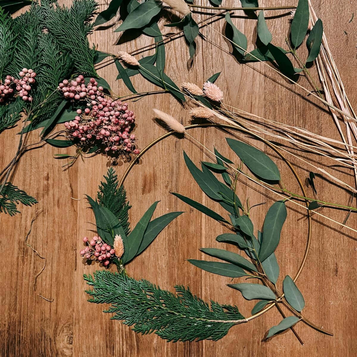 Ring mit verschiedenen Materialien wie Eukalyptus und Trockenblumen auf Tisch – diy weihnachtsdeko, eukalyptus ring.