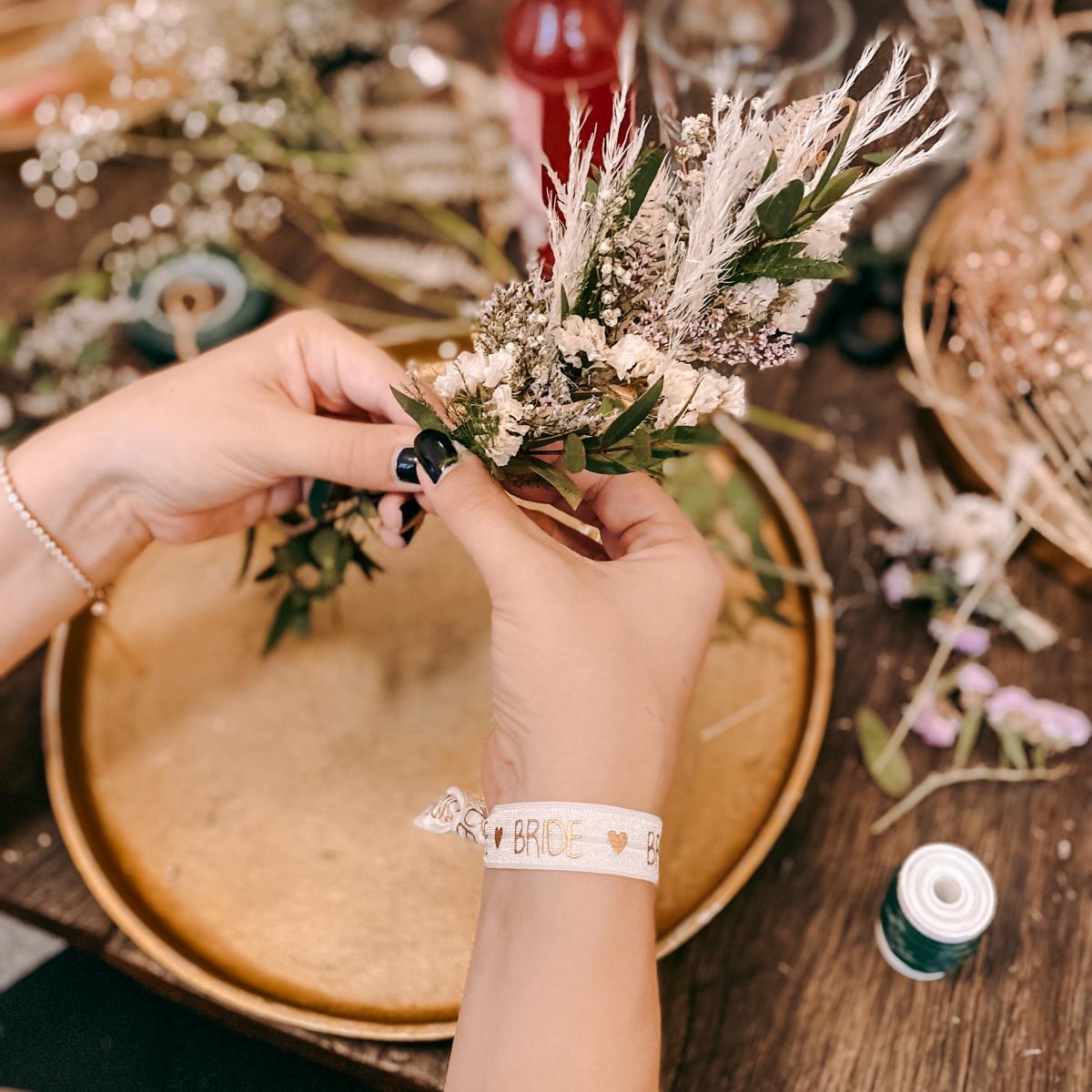 Zwei Hände arrangieren Trockenblumen für Kranz – diy blumenkranz, flower crown, boho blumenkrone