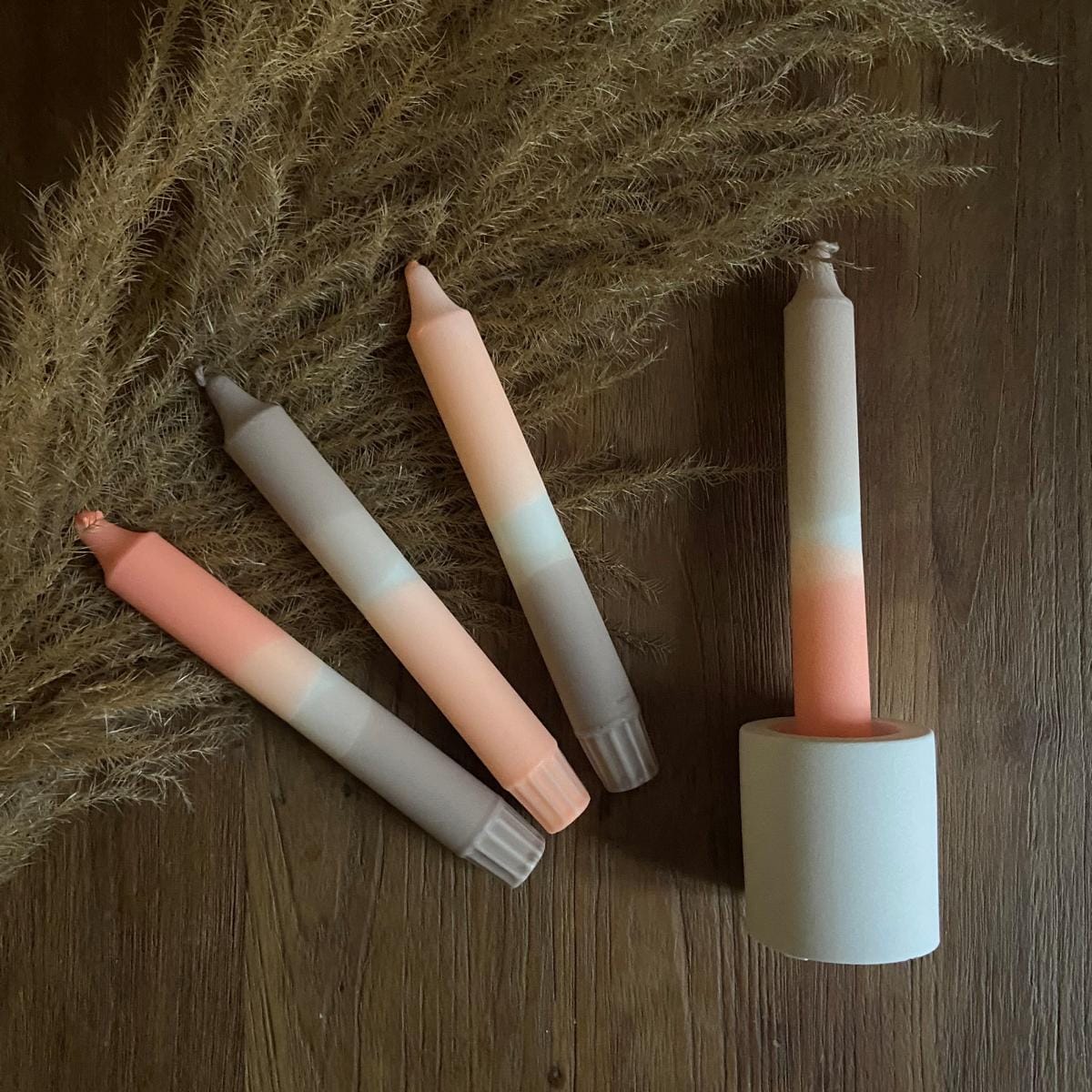 Farbverlaufkerze „Len“ im weißen Ständer auf Tisch – nachhaltige, handgemachte Stearinkerze.