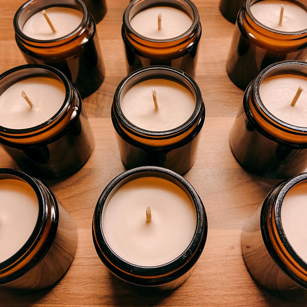 Viele fertige vegane Duftkerzen auf Holztisch – DIY Kerzen Workshop, auch für Firmenevents.
