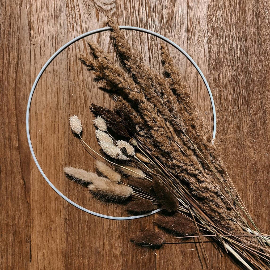 Weißer Trockenblumenring Feldliebe auf Tisch – schlichte und edle Dekoidee mit Naturmaterialien.