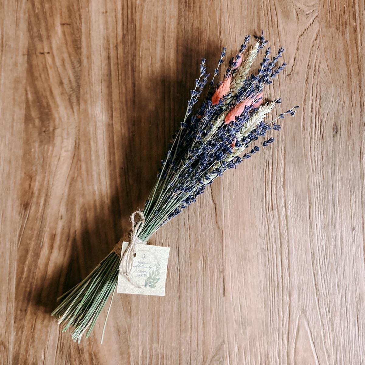 Lavendelblumenstrauß mit Gerste und Lagurus auf Tisch, dekorativer Trockenblumenstrauß für Zuhause oder Geschenk.