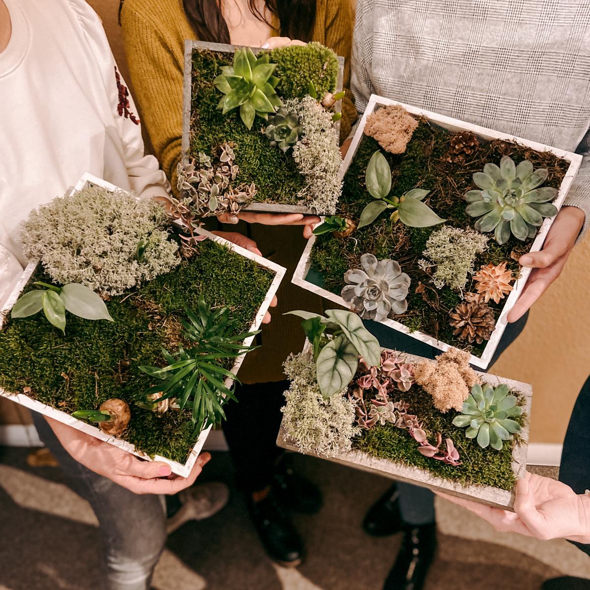 Vier Personen halten ihre fertigen Pflanzenbilder in die Kamera – DIY Pflanzenkunst, Workshop Berlin, Teamevent.