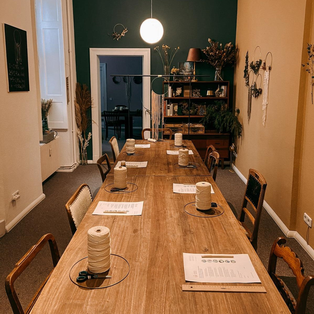 Tisch mit mehreren vorbereiteten Arbeitsstationen – Makramee Workshop Materialien bereit.