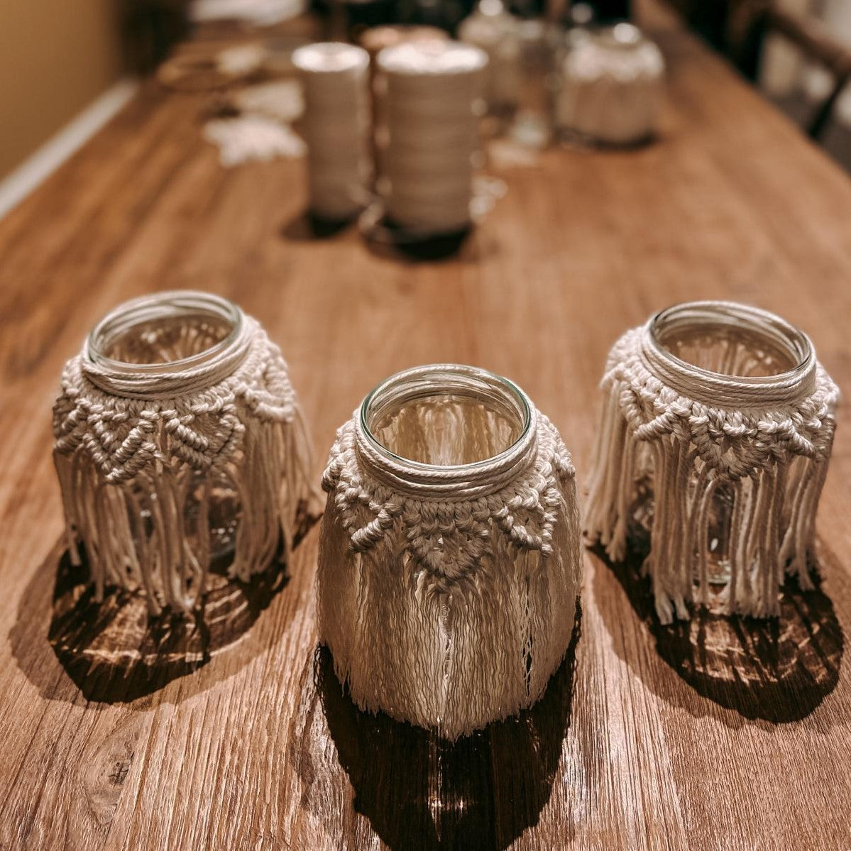 Drei Makramee Lichter mit Garn im Hintergrund – DIY Boho Makramee Glas im kreativen Workshop.