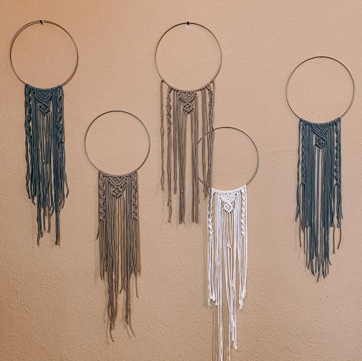 Verschiedene handgefertigte Makramee Ringe an Wand hängend, nachhaltige Boho-Deko