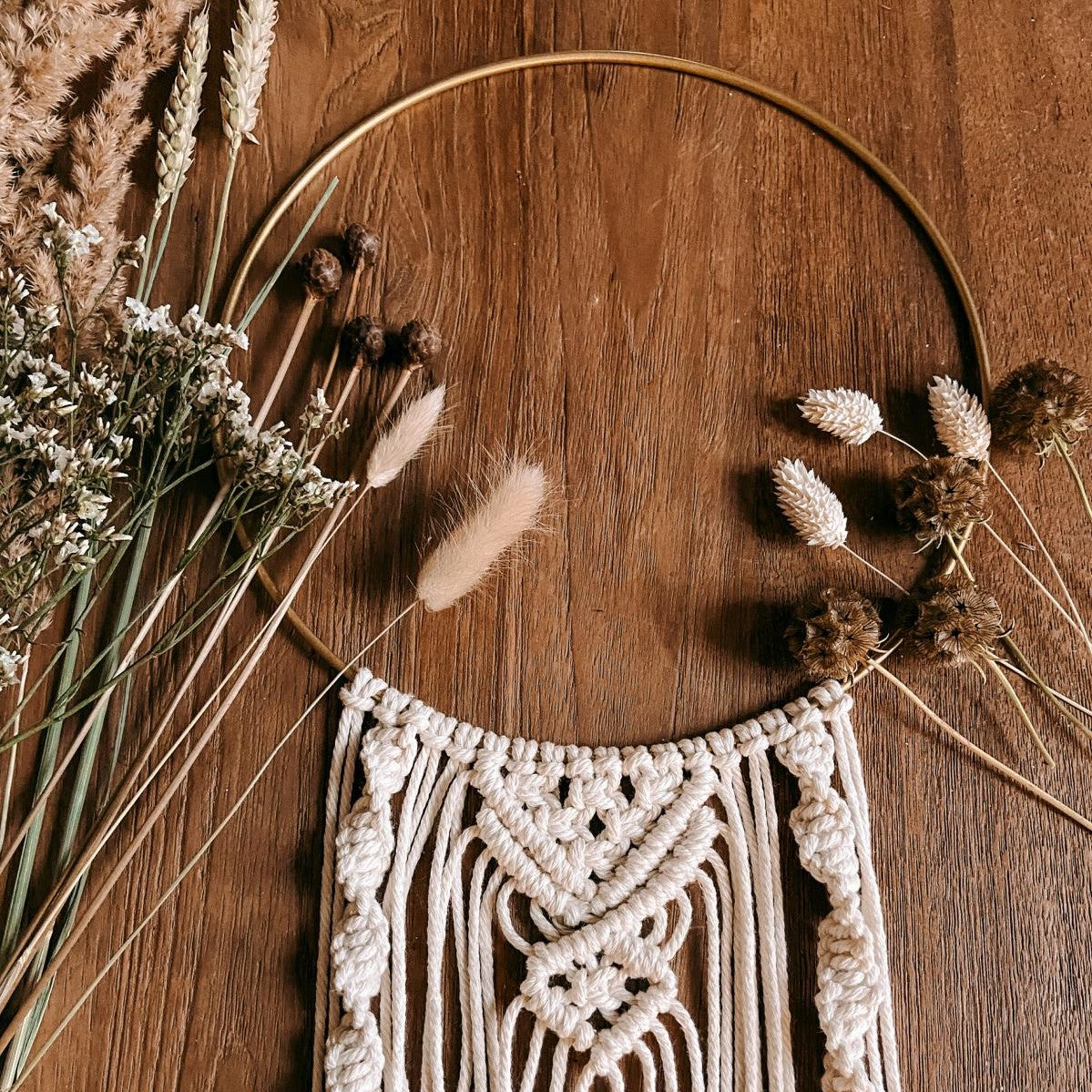 Makramee Ring mit Trockenblumen auf Holztisch – Boho-Stil DIY Workshop für Zuhause.