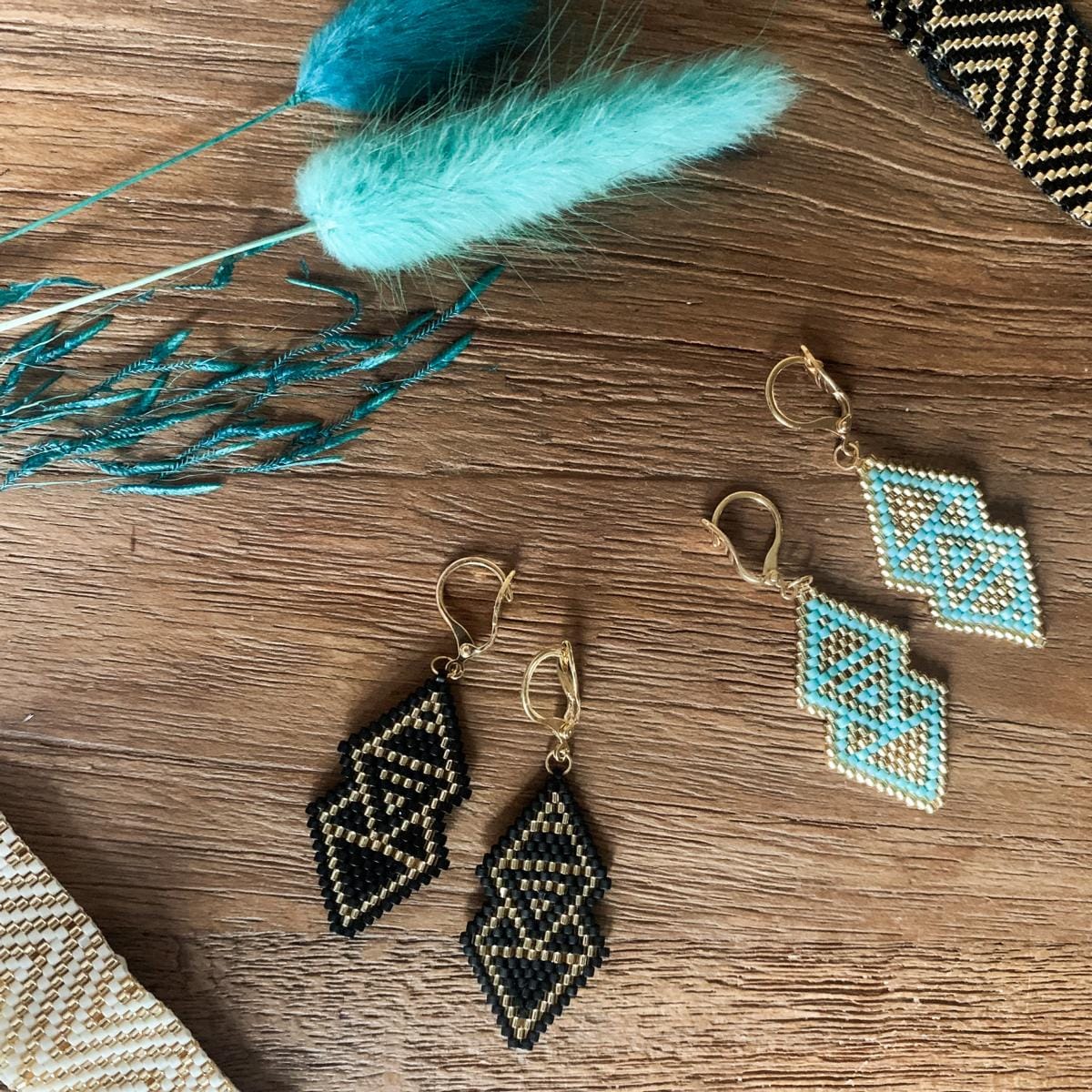 Boho-Ohrhänger schwarz/gold aus Miyuki-Perlen, handgefertigt, Metallteile goldfilled, eleganter Schmuck auf Tisch.