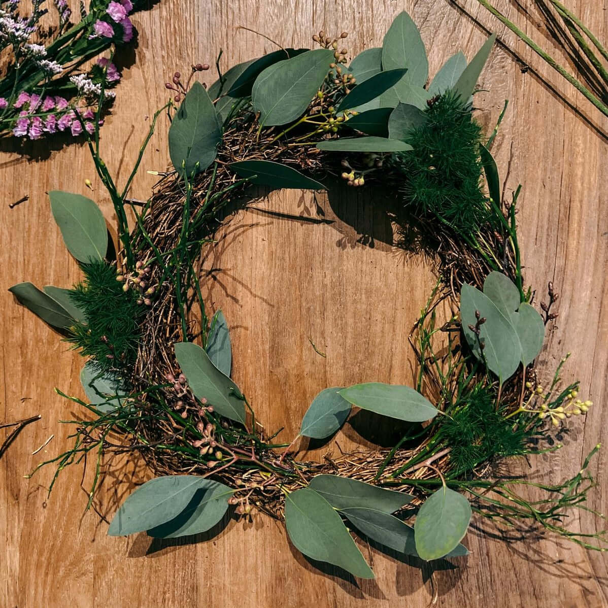 Kranz mit grünen Blättern auf Tisch – Frühlingskranz Workshop, perfekt für JGA.