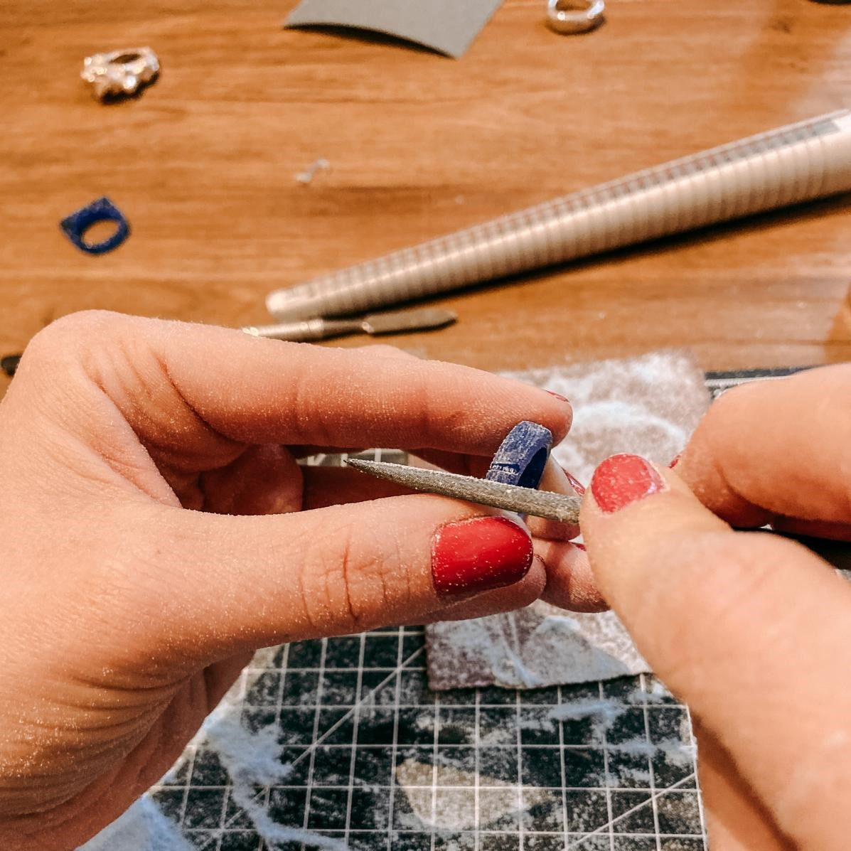 Zwei Hände bearbeiten Plastikringform mit Pfeilen – DIY Ring Workshop, individuelles Schmuckdesign, Goldschmiede.