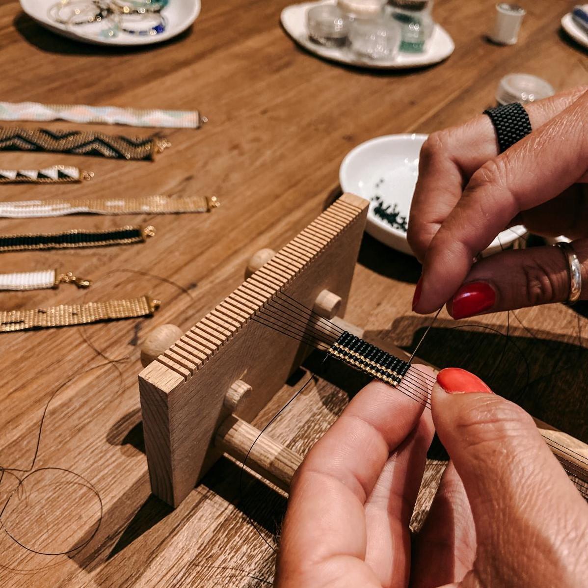 Zwei Hände fädeln Perlen auf Draht – Armband Workshop, japanische Miyuki Glasperlen