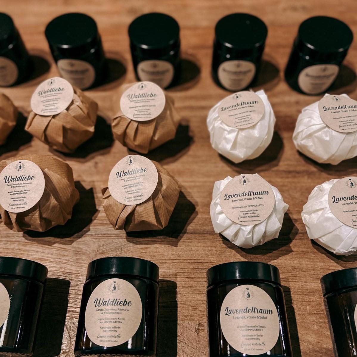 Duftkerze und Badekugel „Lavendeltraum“ auf Tisch verteilt – perfekt für Wellness zuhause.