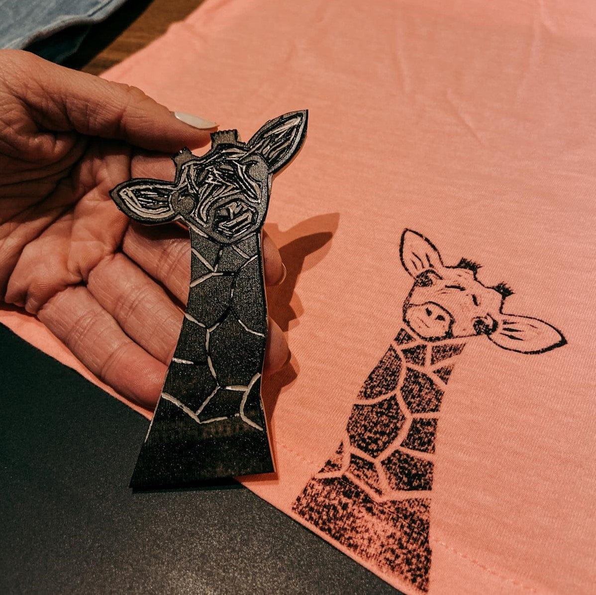 Giraffen-Stempel mit gestempelter Giraffe auf rotem Stoff – textildruck workshop, diy stempel, kreativkurs berlin, auch für Firmenevents.