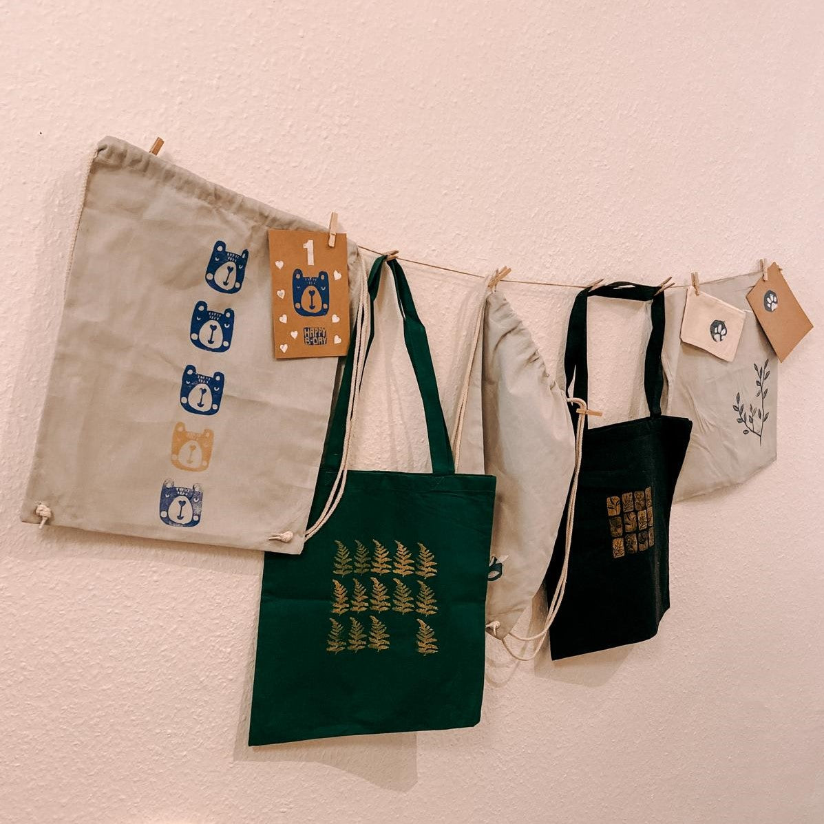 Gestempelte Jutebeutel hängen an Schnur – stoff bedrucken, stempel kunst, kreativ workshop berlin, auch für Firmenevents.