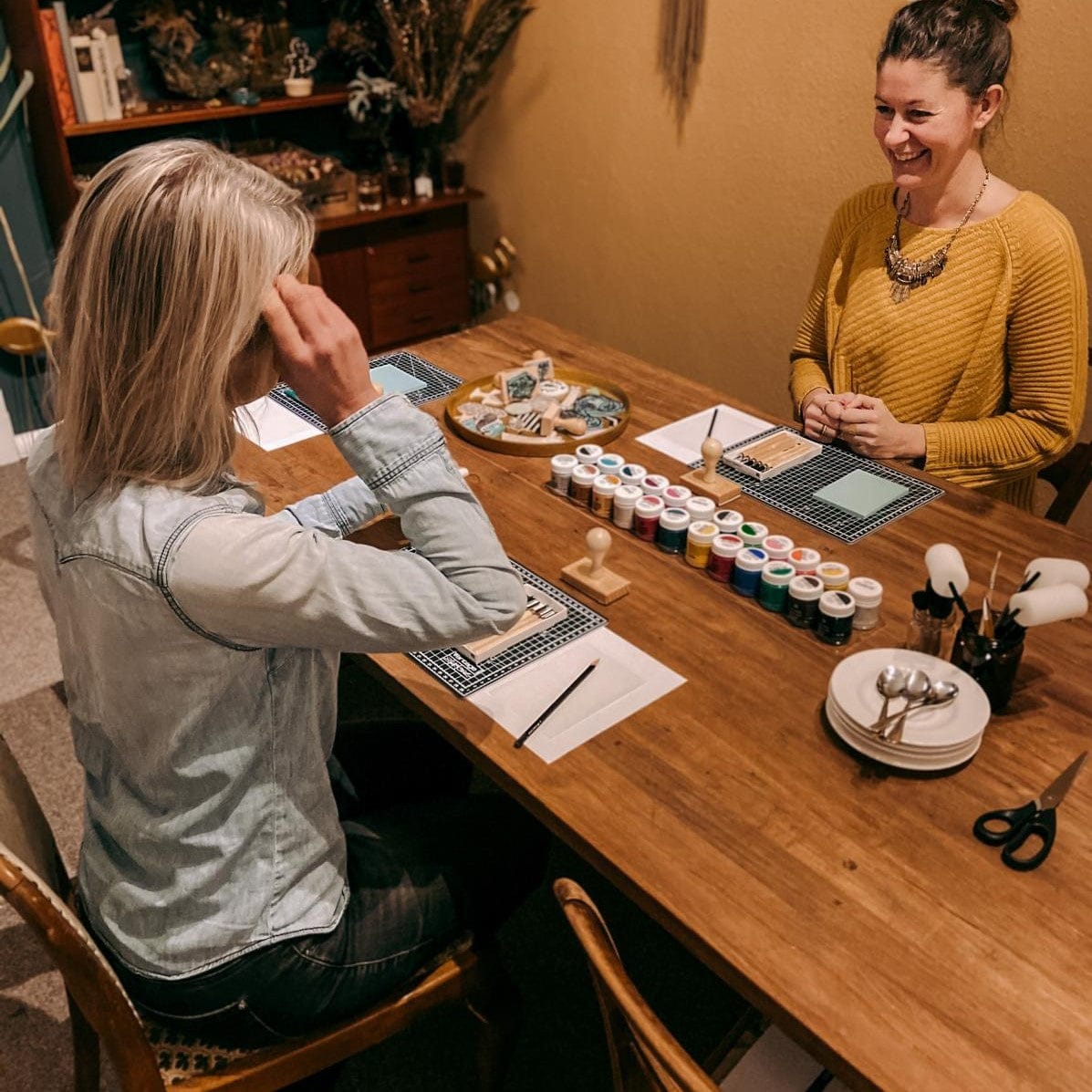 Zwei Personen arbeiten am Tisch mit Farben und Materialien – stempel schnitzen, textildruck workshop, kreative events, auch für Firmenevents.