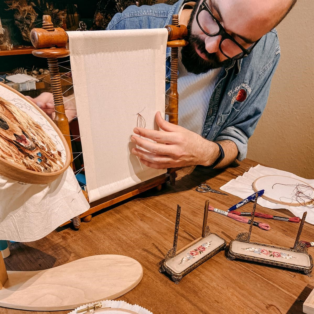 Mann bearbeitet Stoff mit Stickereien und Materialien – Pilz DIY Workshop.