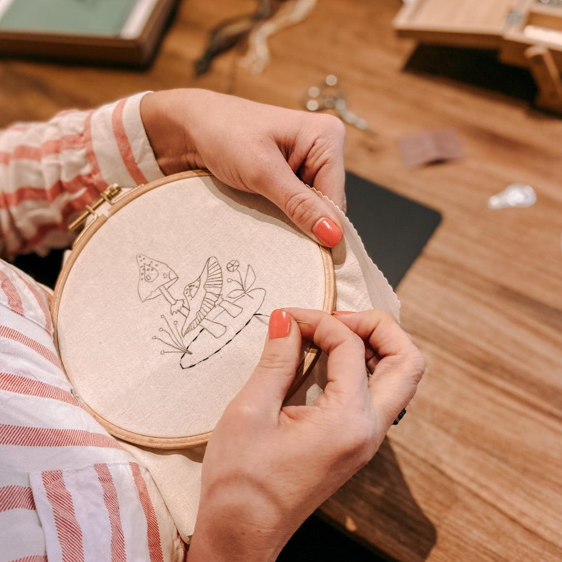 Hand stickt Pilzmotiv in Stoff – Stickworkshop Schritt-für-Schritt Anleitung.