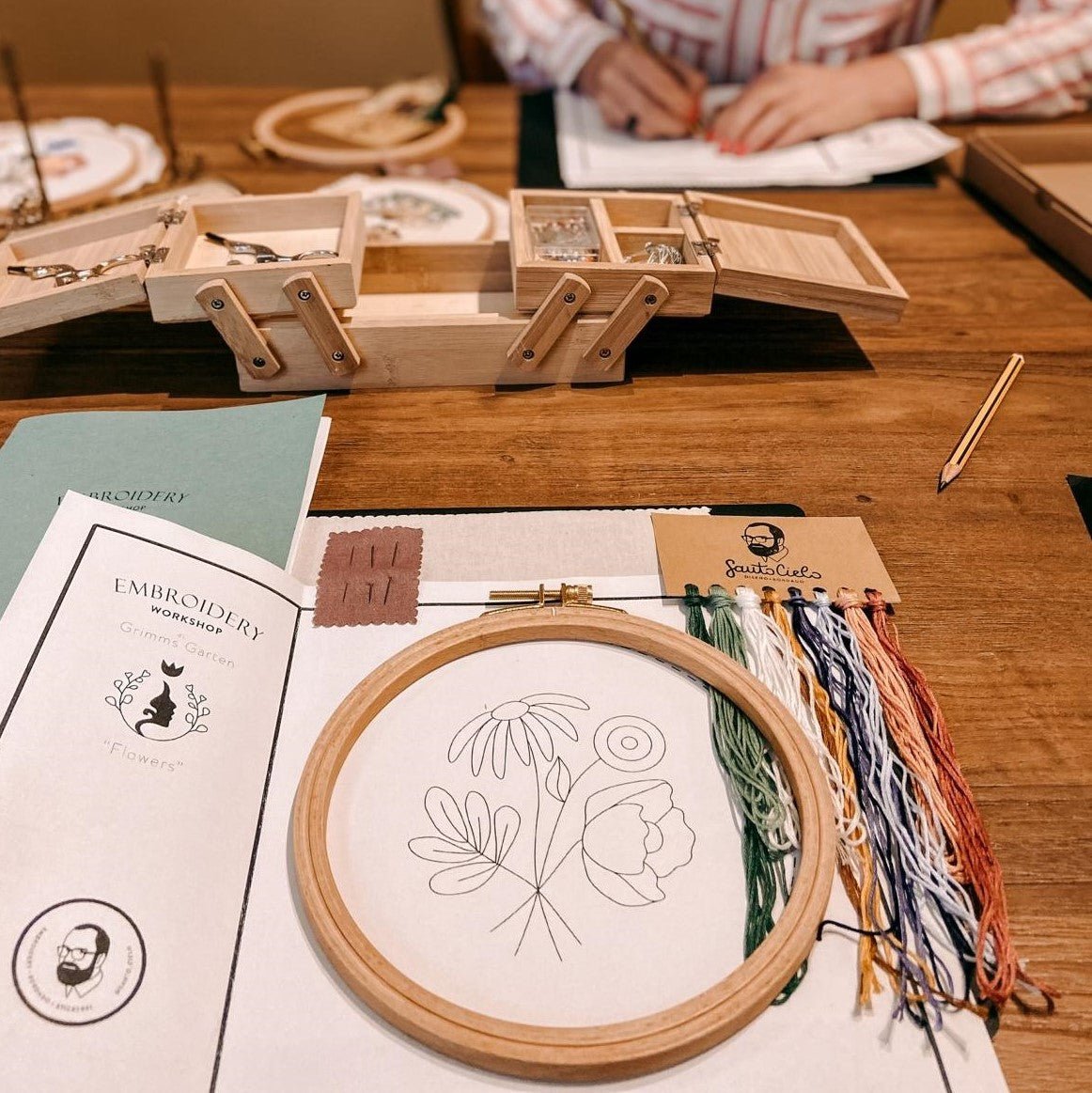 Blumenmotiv auf Stoff mit farbigen Fäden vorbereitet für Stickworkshop.