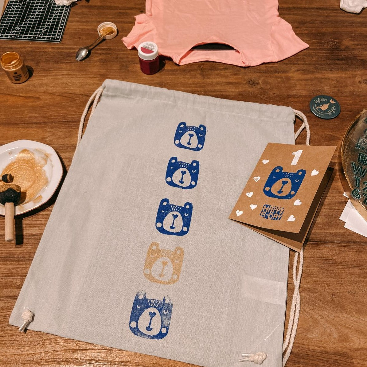 Jutebeutel mit gestempelten Bärenmotiven auf Tisch – textildruck workshop, stoff bedrucken, stempel kunst, auch für Firmenevents.