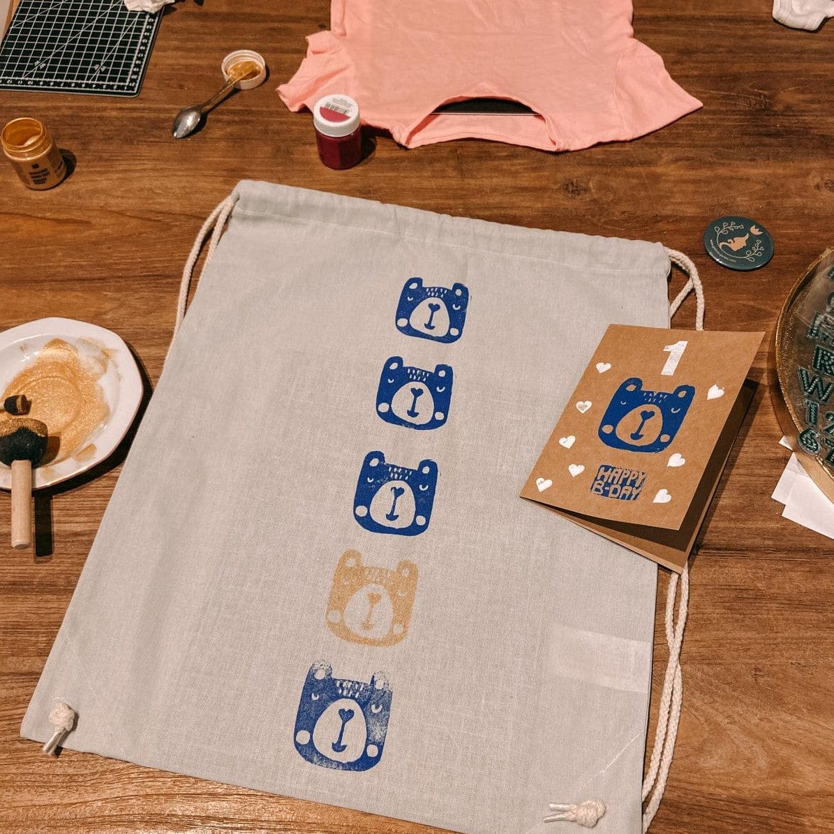 Jutebeutel mit gestempelten Bärenmotiven auf Tisch – textildruck workshop, stoff bedrucken, stempel kunst, auch für Firmenevents.