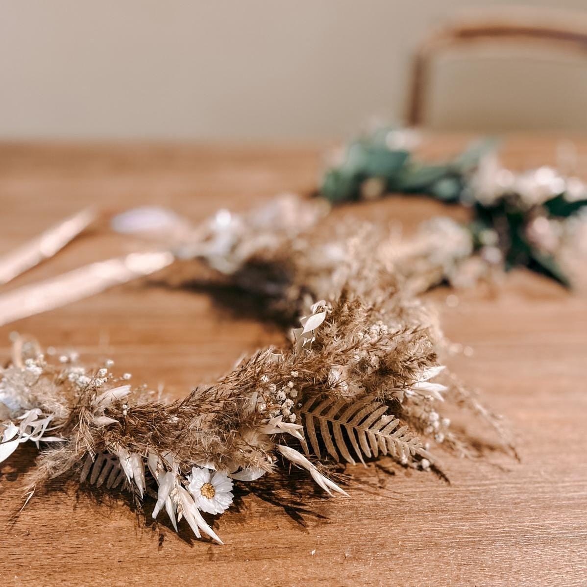 Nahaufnahme fertiger Blumenkrone auf Holztisch – diy blumenkranz, flower crown, boho kranz selber machen