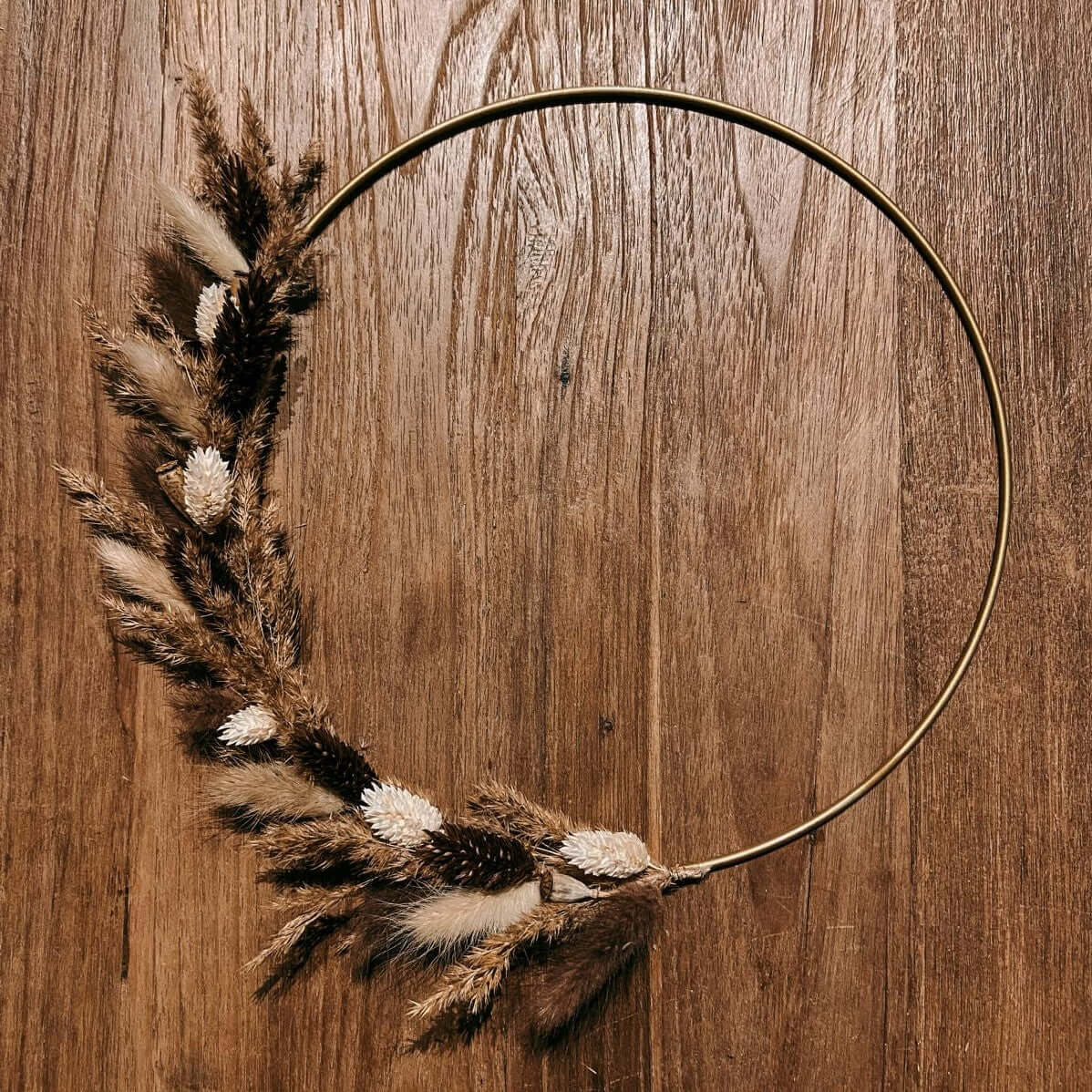 Fertiger Trockenblumenring Feldliebe auf Tisch – nachhaltige Wanddekoration mit Naturmaterialien.