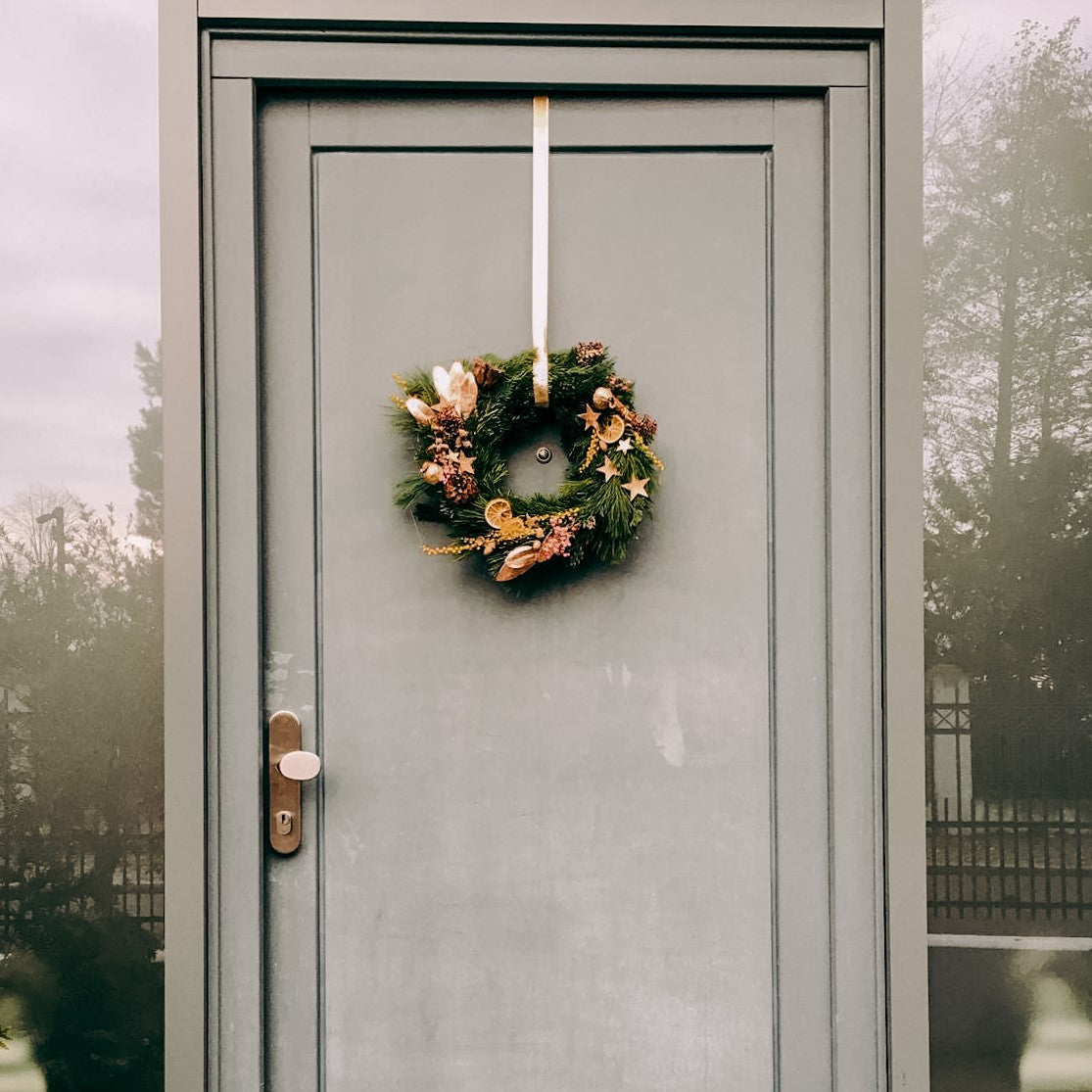 Tür mit hängendem Weihnachtskranz, gesamte Tür im Blick – weihnachtskranz tür, weihnachtsworkshop berlin, auch für Firmenevents.