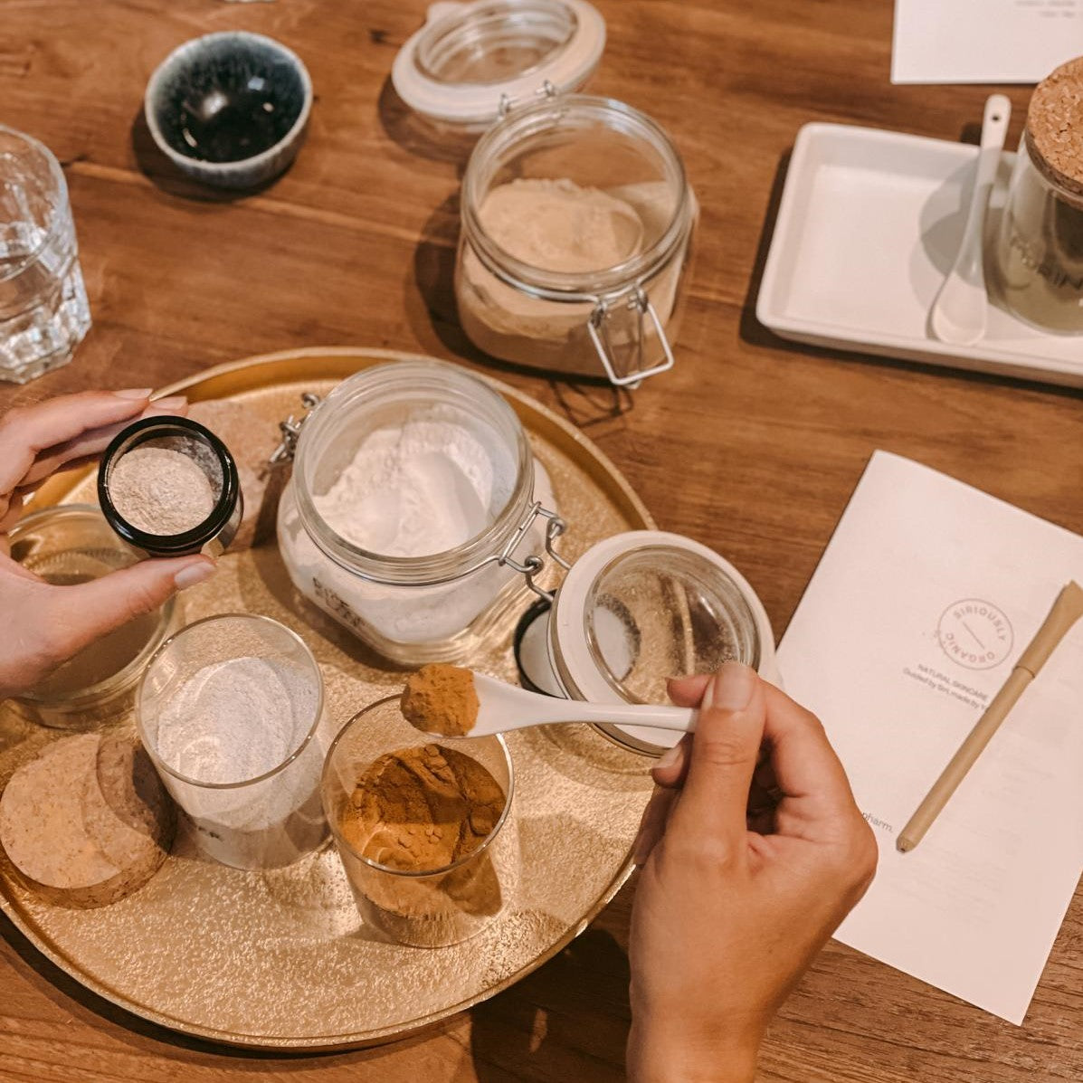 Goldenes Tablett mit verschiedenen Pulvern – DIY vegane Gesichtsmasken Workshop.