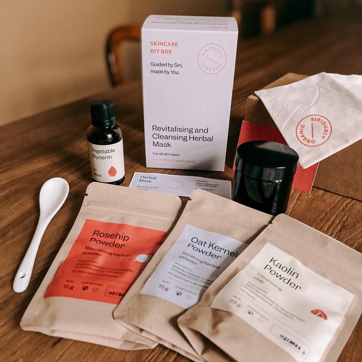 Alle Materialien für DIY Gesichtsmaske ausgebreitet – Kaolin, Hagebutte, Hafer und Glycerin.