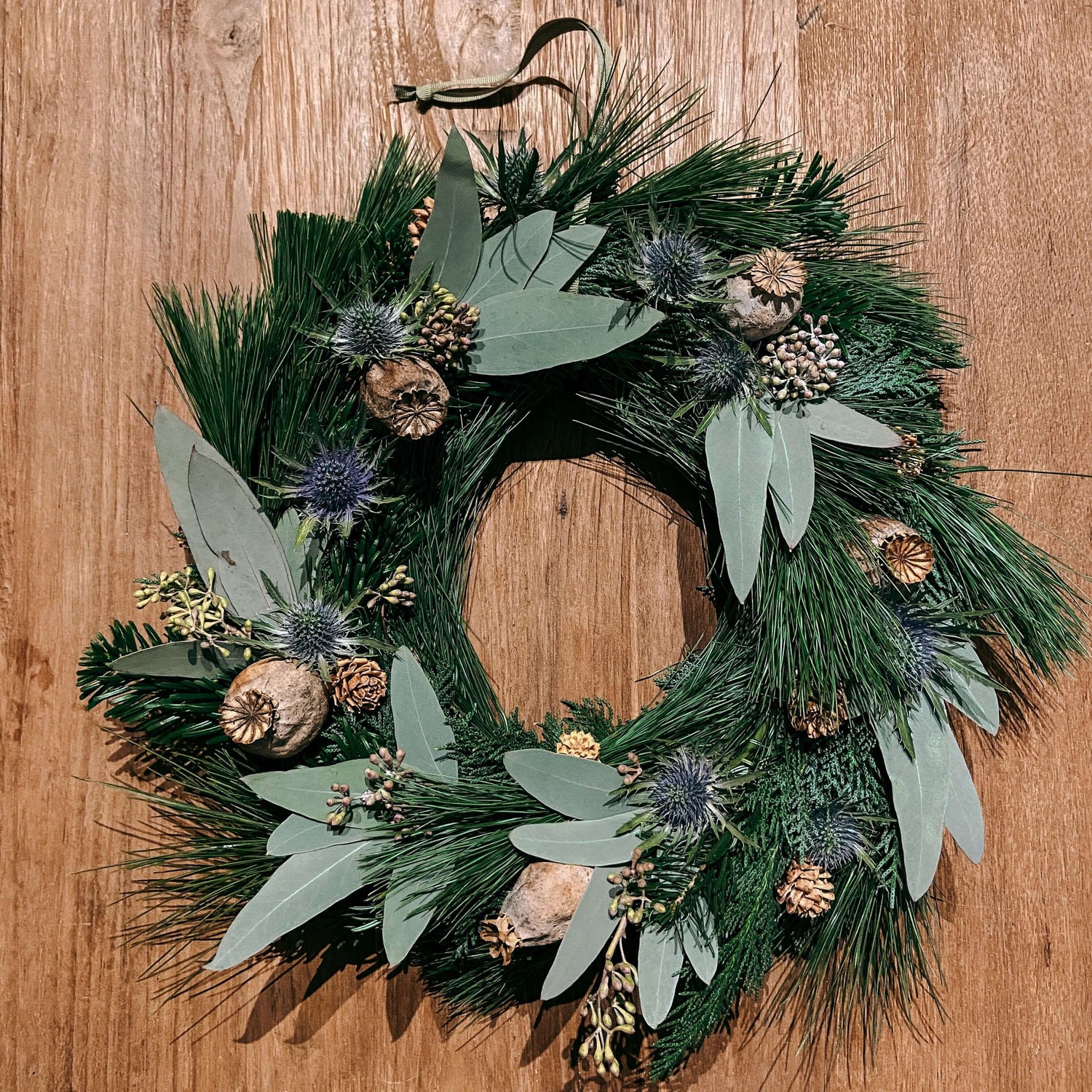 Fertiger Kranz mit Eukalyptus und Trockenblumen auf Tisch – eukalyptus kranz, weihnachtsdeko, auch für Firmenevents.